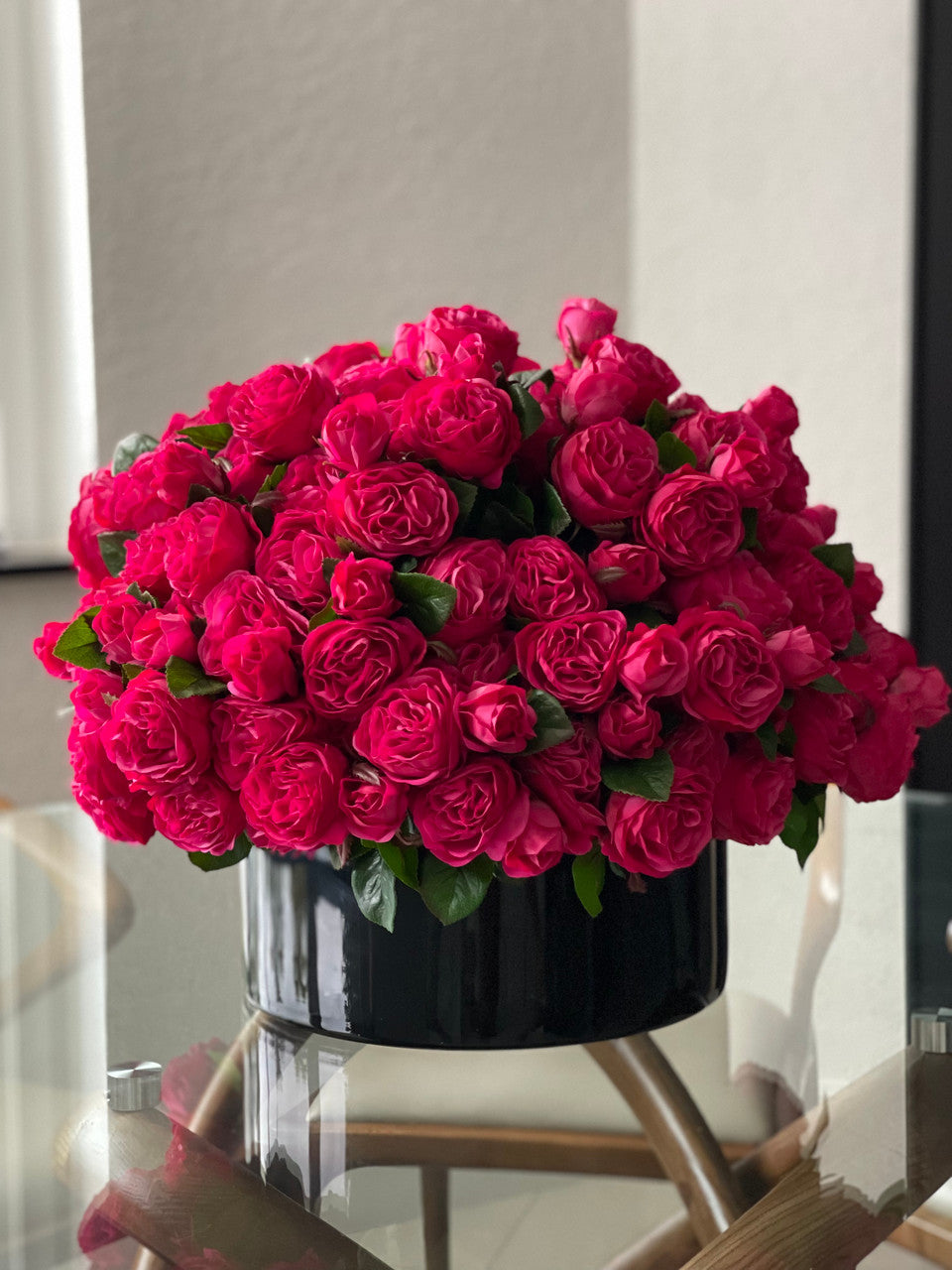 Roses anglaises rose foncé dans vase en verre plat noir