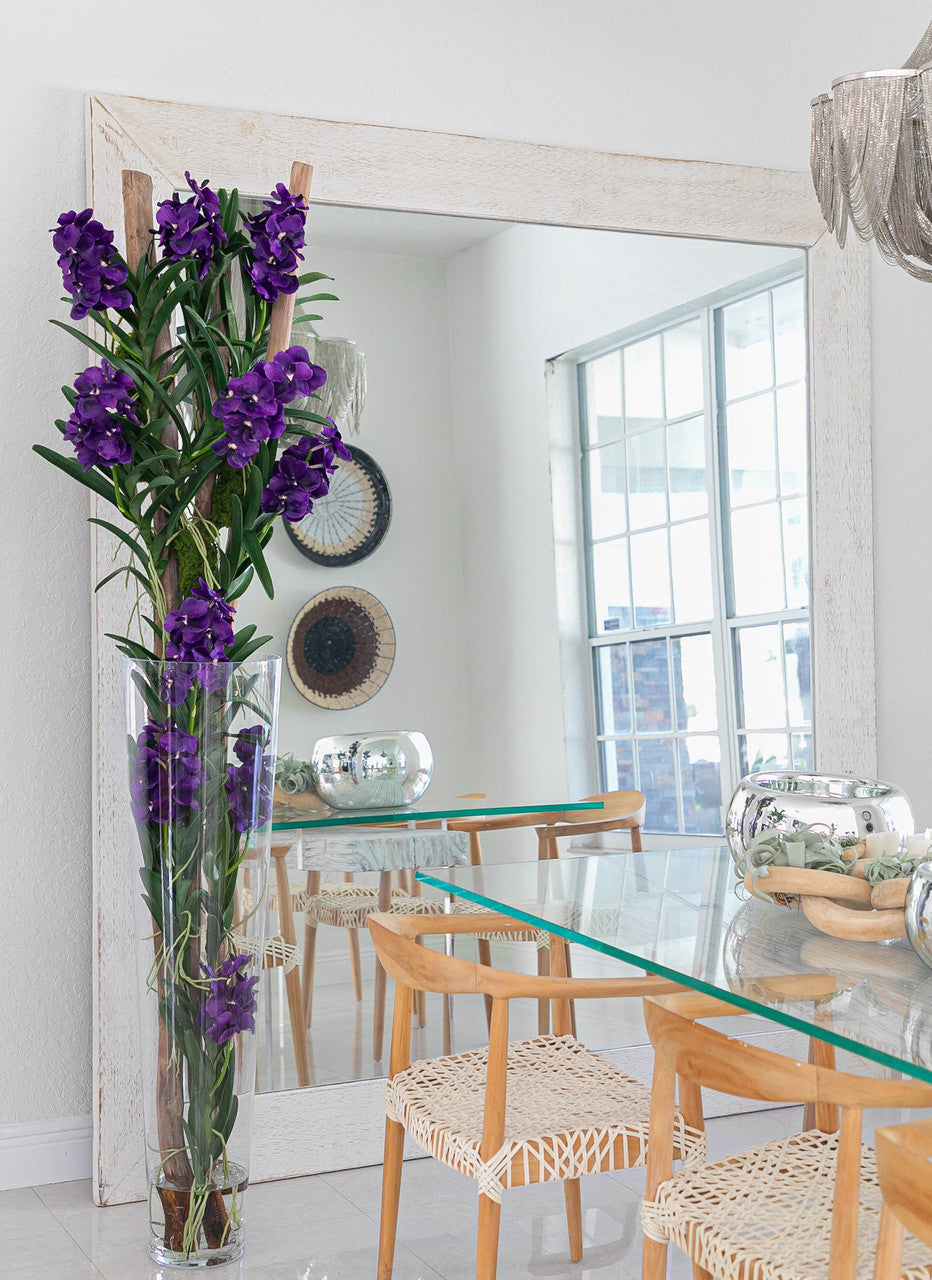 Orchidées Vanda violettes et bois flotté dans un cylindre en verre effilé surdimensionné