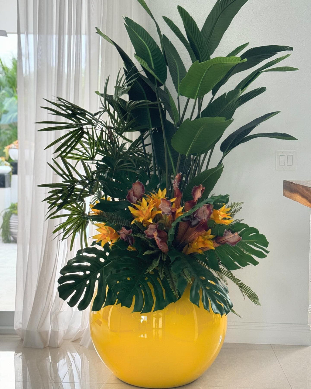Plantes tropicales mélangées dans cache-pot globe jaune