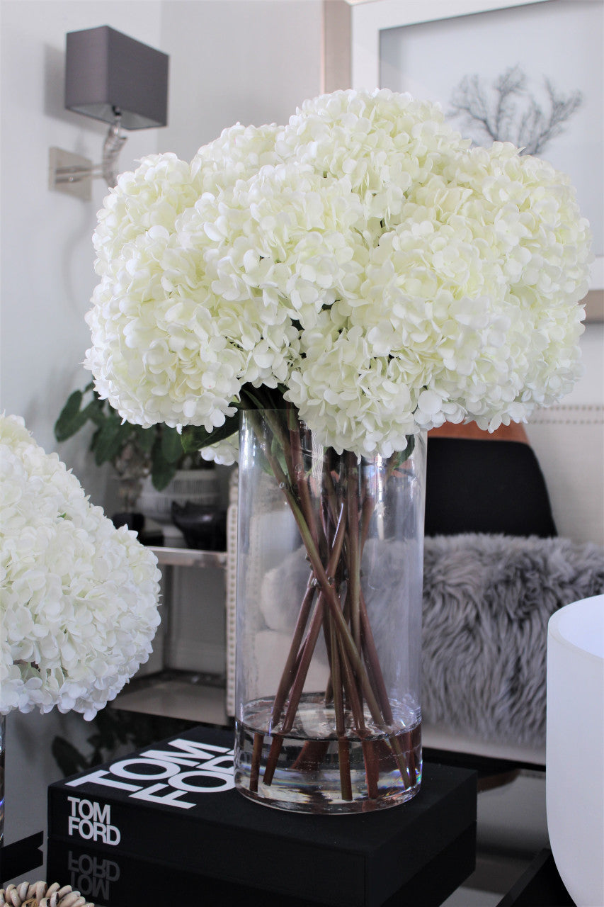 Bouquet d'hortensias blancs dans vase cylindre en verre transparent haut
